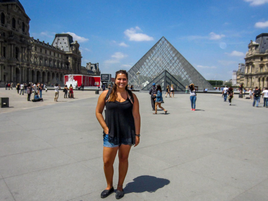 Overweight and traveling Girl standing in front of the Louve