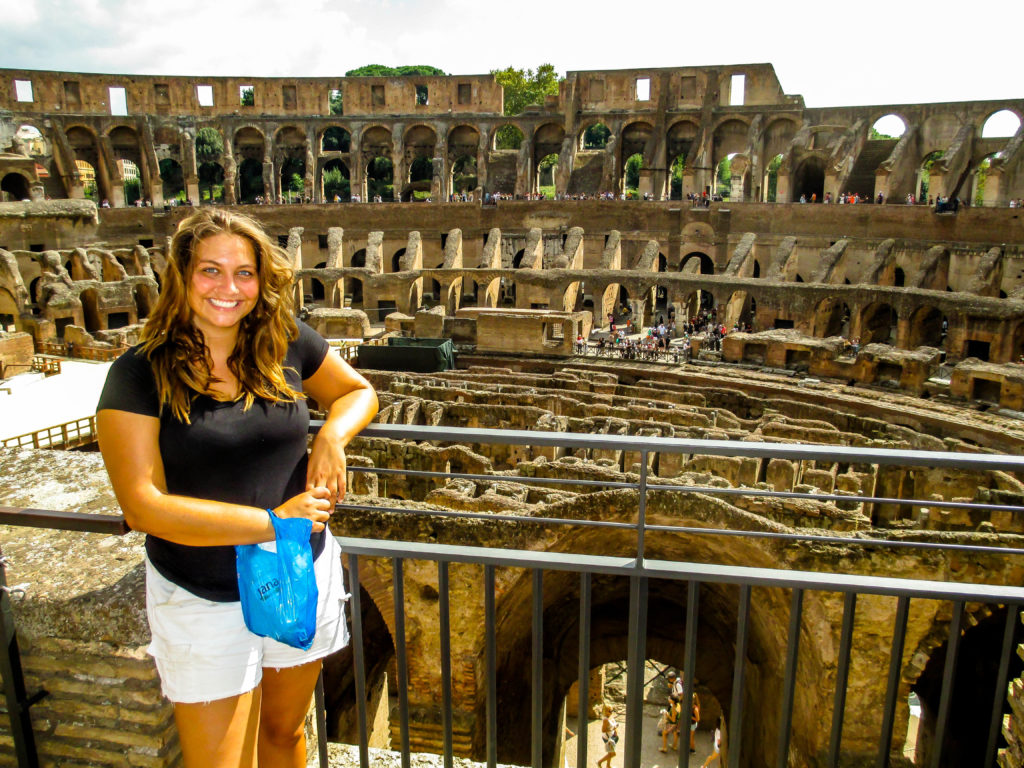 Overweight and traveling girl standing in front of the Coliseum 