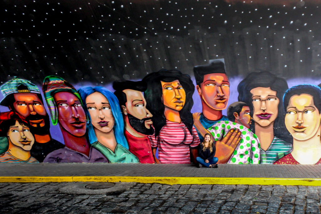 Girl in front of mural of different colored people