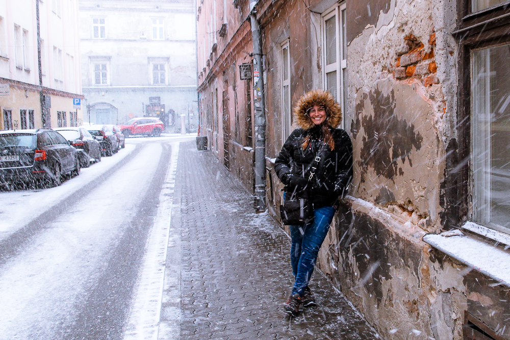 Girl leaning on wall in snowy Krakow Poland